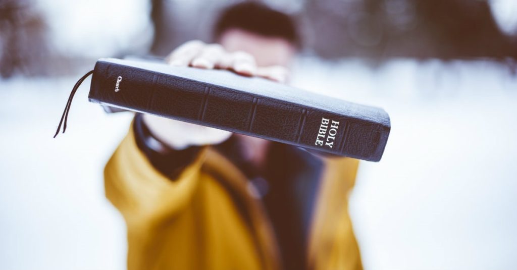 Man holding holy bible - Truth Of Christ Ministries T.O.C.M